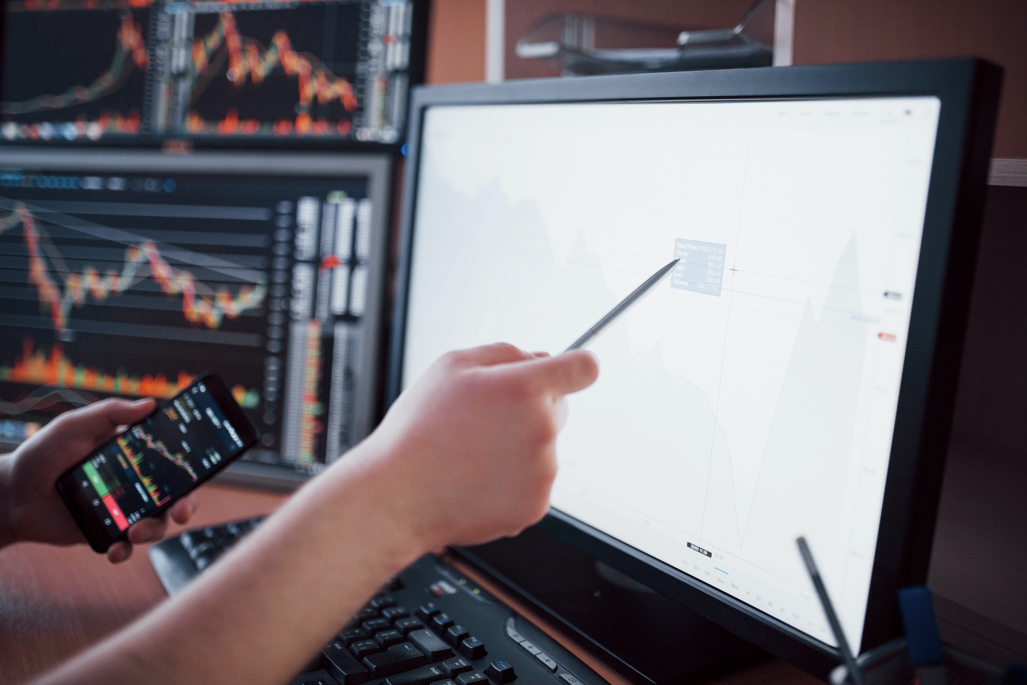 Analyzing data. Close-up of young businessman pointing on the data presented in the chart with pen
